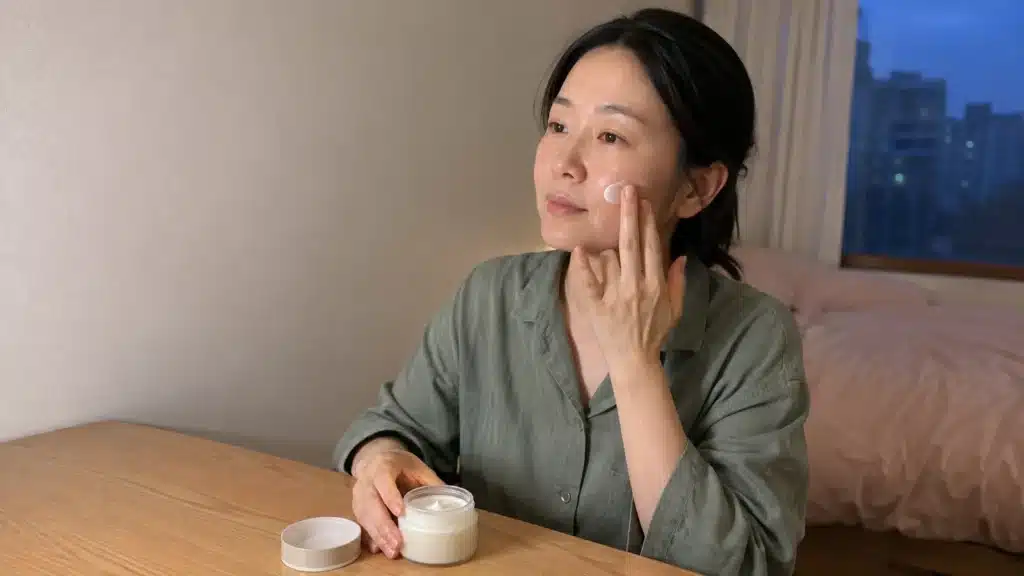 저녁 세안 뒤 피부 장벽 크림을 볼에 바르는 여성