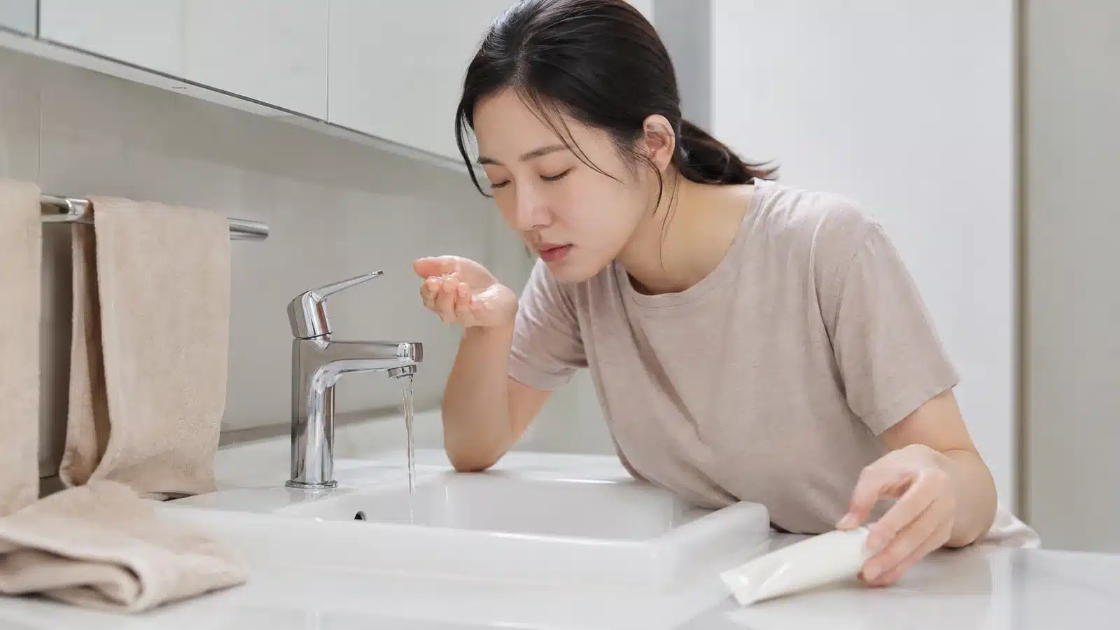 세면대 앞에서 선크림 사용을 멈추고 눈 세척을 준비하는 성인
